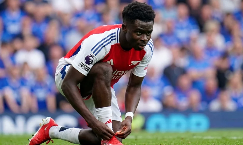 Профессиональный футболист завязывает бутсы перед выходом на поле, будь готов побеждать с 1хбет